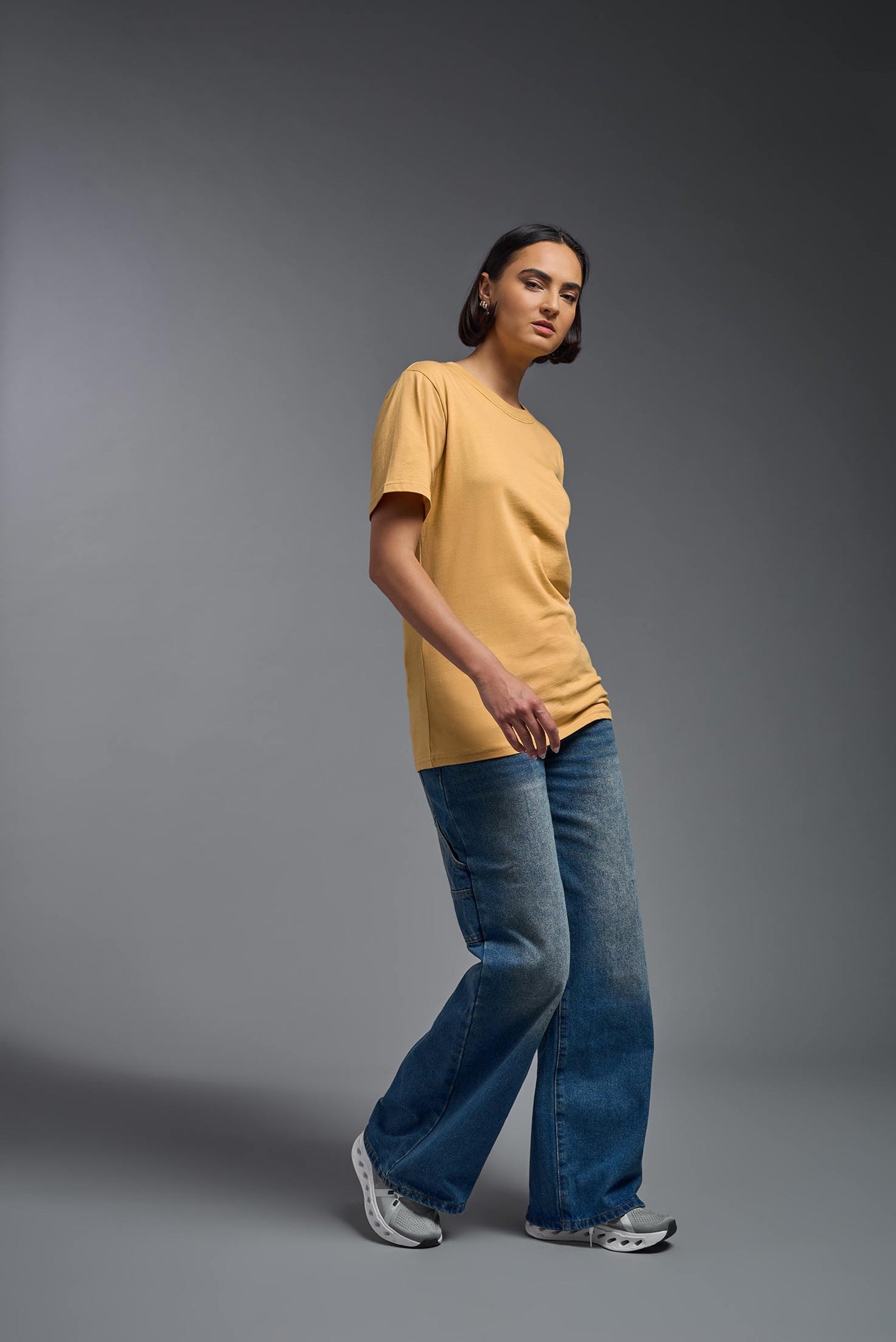 A female model wearing the unisex Organic Soft Cotton T-shirt in the color harvest, made from 100% certified organic cotton, shot from a full body side view. This shirt is unisex and made in the USA. #color_harvest