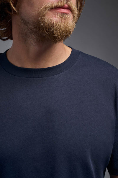 A male model wearing the unisex Organic Soft Cotton T-shirt in the color nova, made from 100% certified organic cotton, shot from a collar close up view. This shirt is unisex and made in the USA. #color_nova