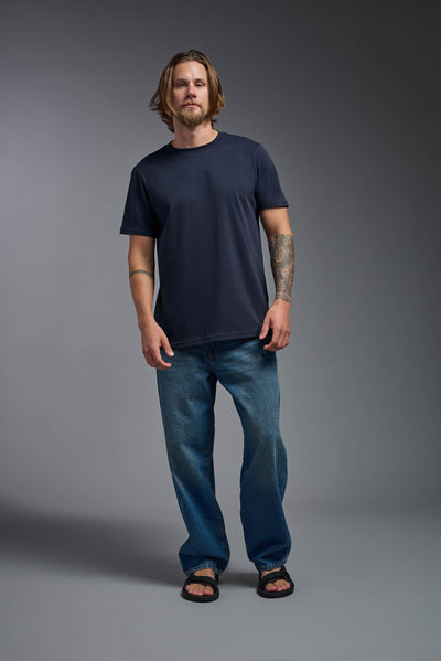 A male model wearing the unisex Organic Soft Cotton T-shirt in the color nova, made from 100% certified organic cotton, shot from a full body front view. This shirt is unisex and made in the USA. #color_nova