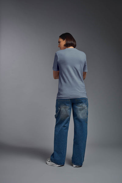 A female model wearing the unisex Organic Soft Cotton T-shirt in the color canyon blue, made from 100% certified organic cotton, shot from a full body back view. This shirt is unisex and made in the USA. #color_canyon-blue
