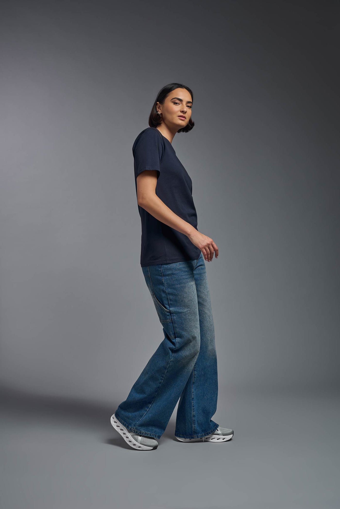 A female model wearing the unisex Organic Soft Cotton T-shirt in the color nova, made from 100% certified organic cotton, shot from a full body side view. This shirt is unisex and made in the USA. #color_nova