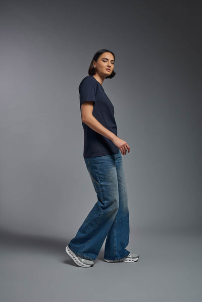 A female model wearing the unisex Organic Soft Cotton T-shirt in the color nova, made from 100% certified organic cotton, shot from a full body side view. This shirt is unisex and made in the USA. #color_nova